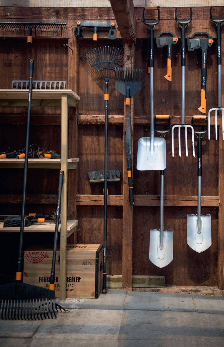 Drewniane półki i metalowe haki - tak można przechowywać narzędzia ogrodowe w garażu