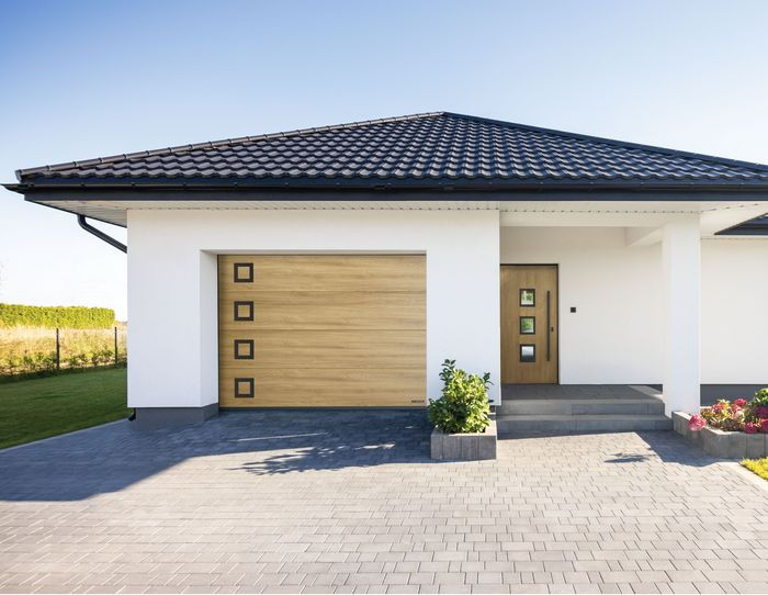 Czarne dodatki do bramy garażowej w duecie z drzwiami wejściowymi w tym samym designie