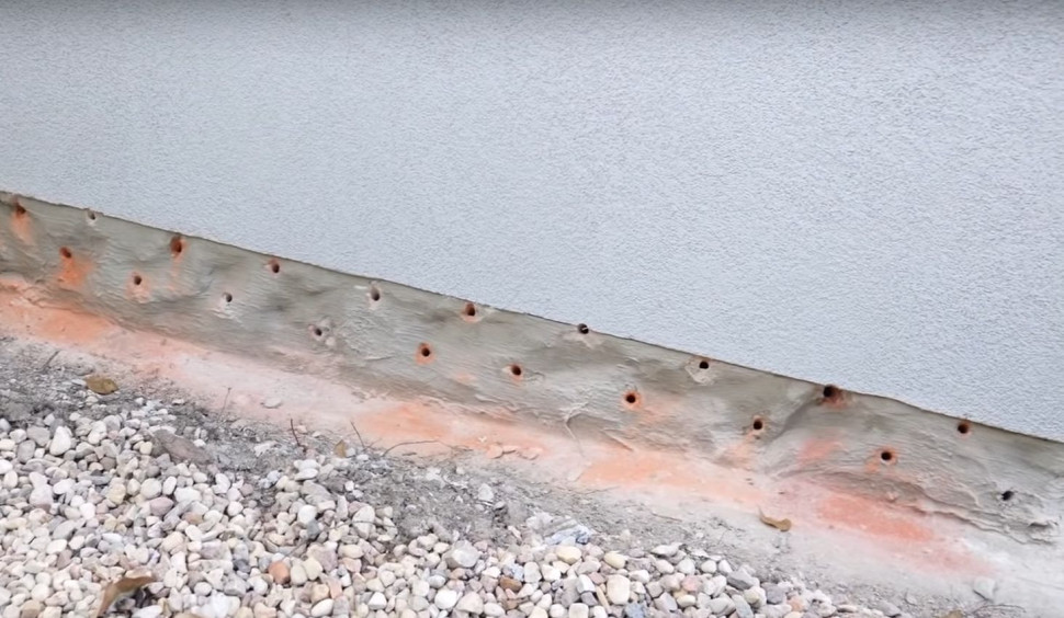 Dwa rzędy otworów iniekcyjnych w ścianie budynku na zewnątrz. fot. Ultrament