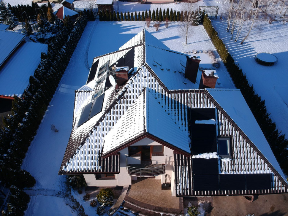 Nad garażem, od strony południowego wschodu, zamontowano panele PV, w garażu falownik, licznik