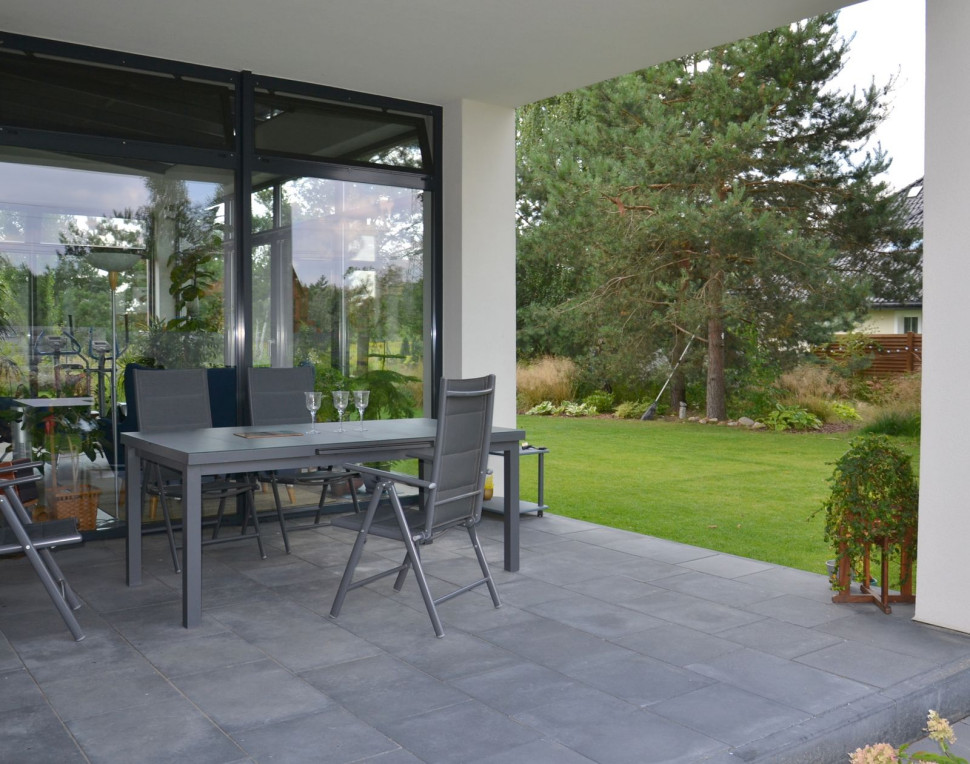 Taras, ulokowany od strony zachodu i północy, wykończono wyrobami z betonu