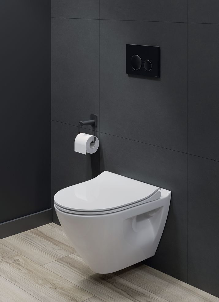 Przycisk spłukujący zamontowany na ściance za muszlą