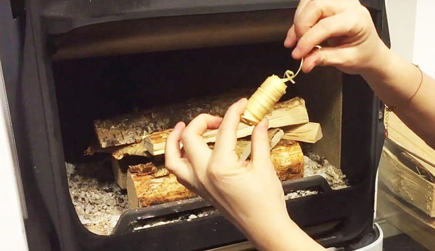 Ułóż kilka kawałków podpałki na górnej warstwie szczap