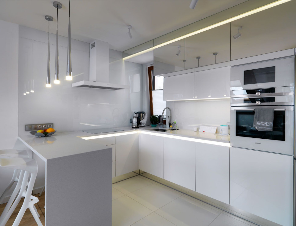 Aranżacja kuchni ze szklaną ścianą i dedykowanym oświetleniem