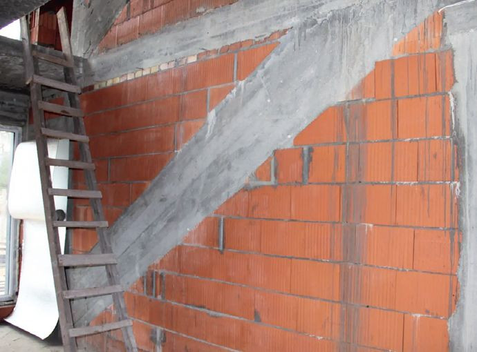 Umieszczenie w ścianie nośnej belki konstrukcyjnej schodów wspornikowych, jednostronnie osadzonych w ścianie