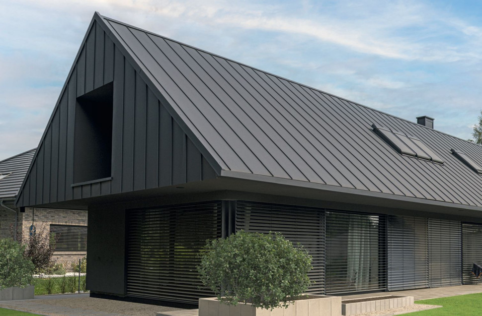 Nowoczesna wersja tradycyjnej bryły z blachą płaską nie tylko na dachu, ale i na części elewacji