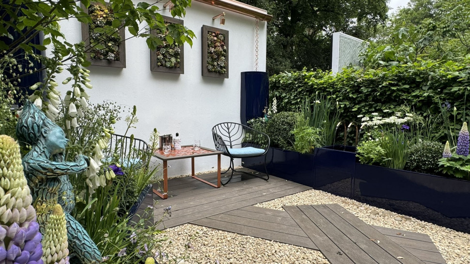 Symetryczny układ donic, mieszanie materiałów nawierzchni i zastosowanie kontrastowych pojemników. Tu dodatkowo system gromadzenia deszczówki w pojemnikach w ogrodzie pokazowym The water saving Garden projektu Sama Proctor’a