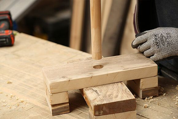 Za pomocą wiertła płaskiego o średnicy większej niż średnica kija od miotły wywierć otwory w każdym z 18 fragmentów desek o długości 100 mm oraz w centralnym punkcie swojego stojaka na choinkę.