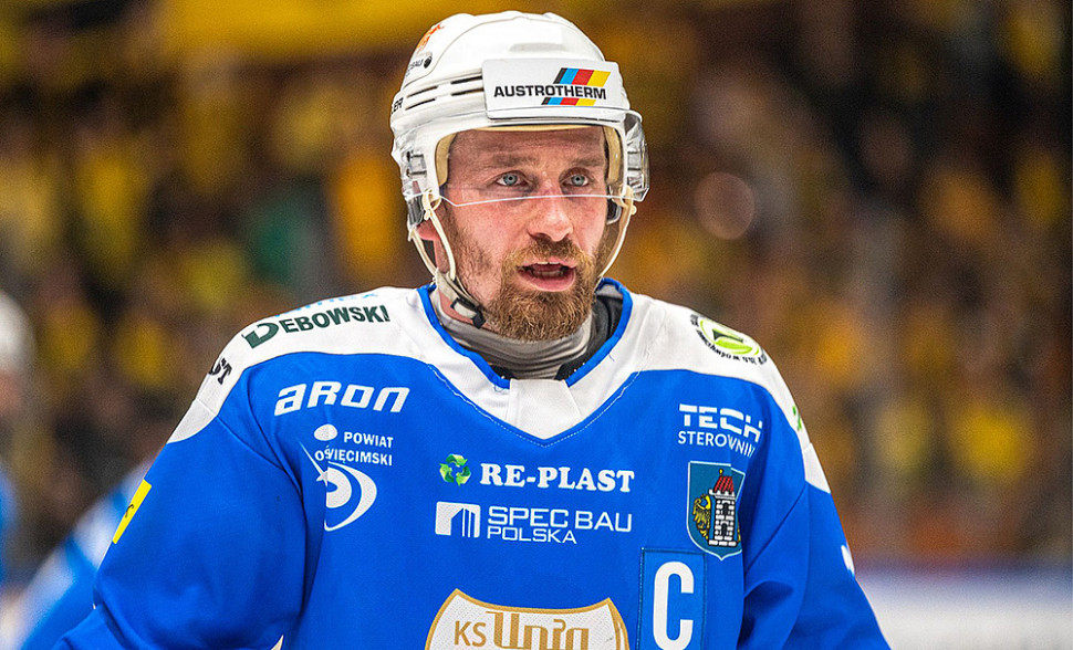 Zawodnik drużyny hokejowej Unia Oświęcim z logo Austrutherm na kasku