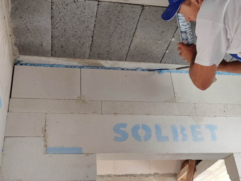 Szczelina podstropowa w ścianie działowej wypełniona materiałem trwale elastycznym.